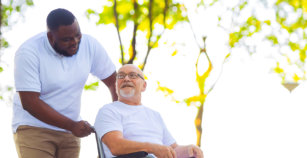 Caregiver and old man in a wheelchair.