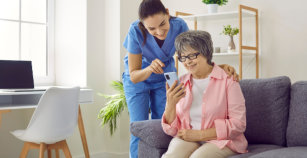 Friendly young nurse teaches older female patient