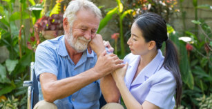 Young nurse take care senior man at home