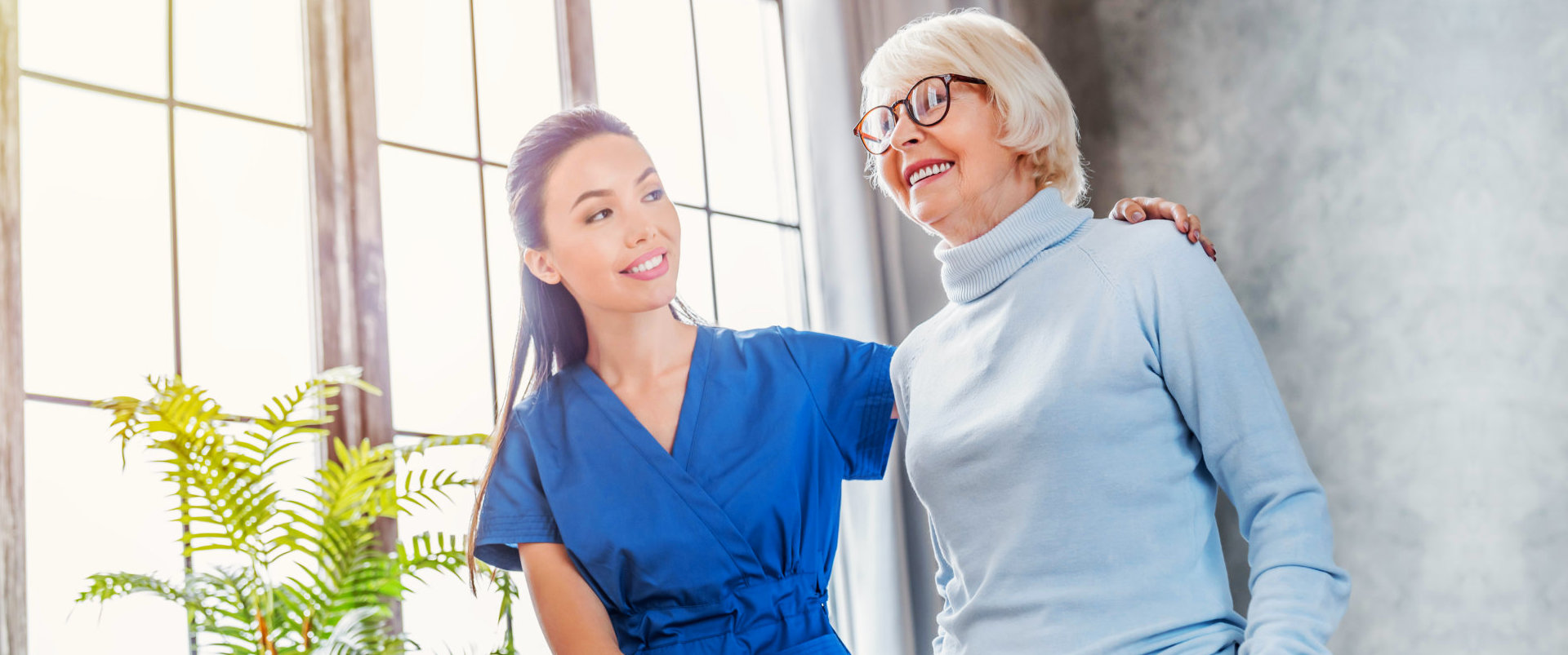 Caregiver helping elderly to walk