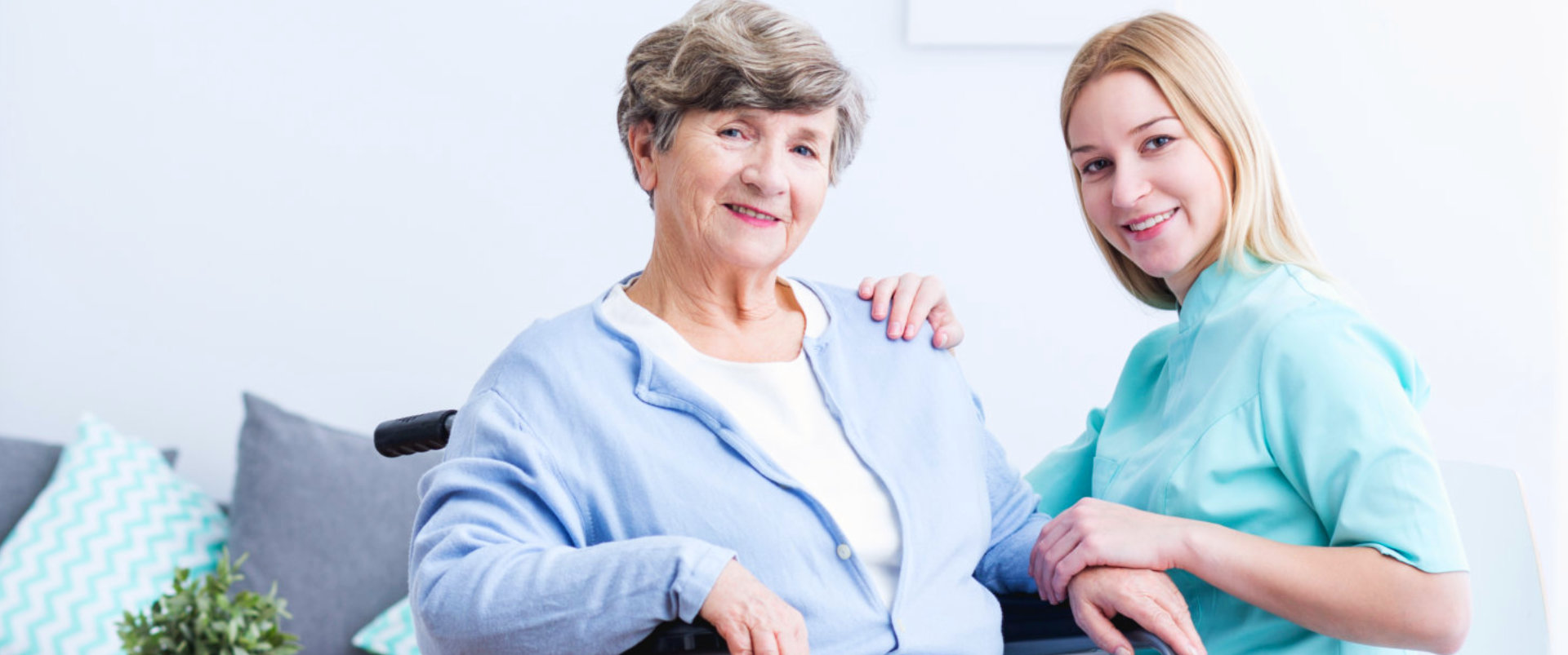 Elderly and Caregiver smilling at the camera