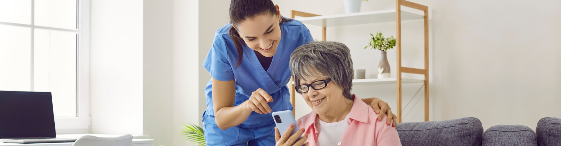 Friendly young nurse teaches older female patient