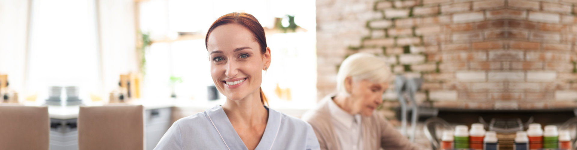 Beautiful hard-working caregiver wearing uniform smiling