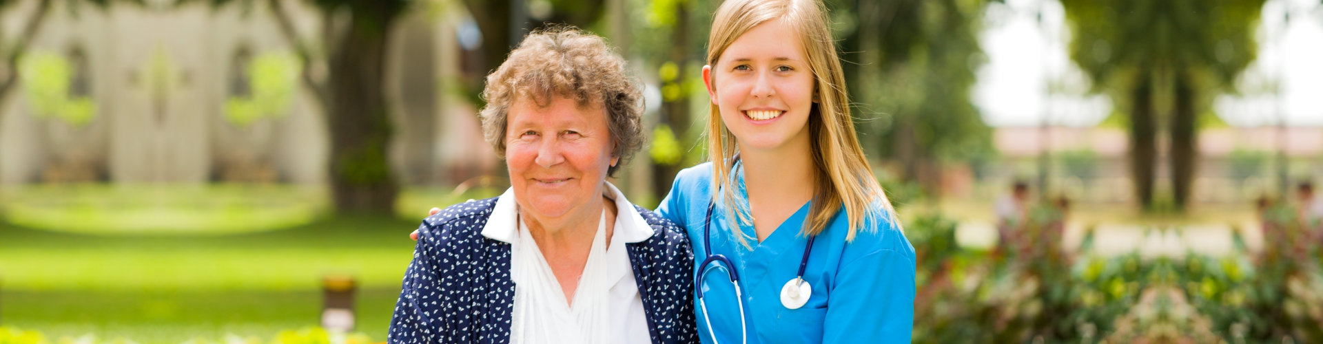 Caregiver together with elderly smiling