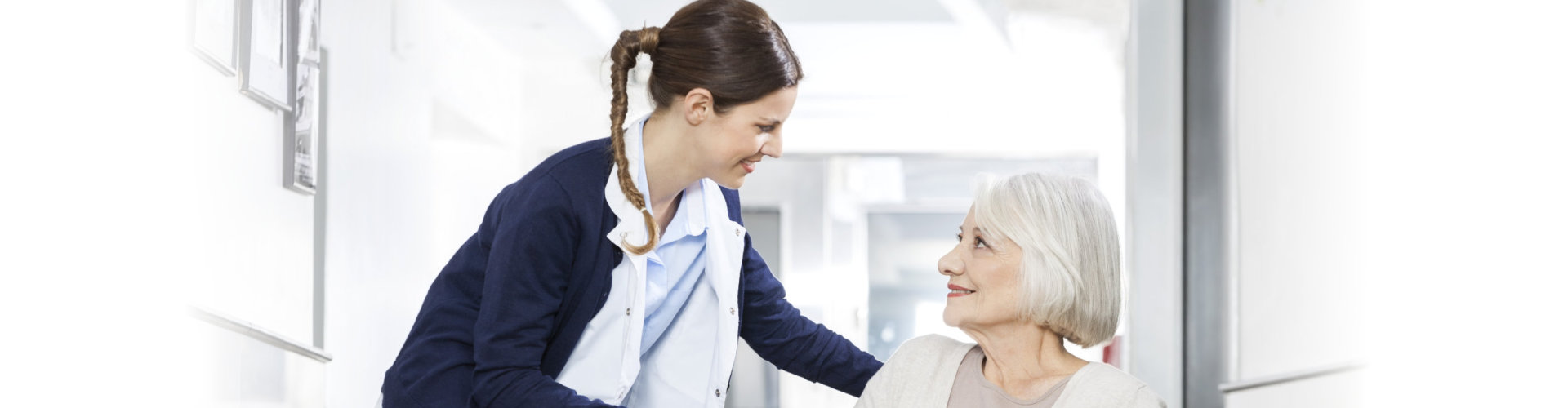 Physiotherapist Consoling Senior Woman Sitting In Wheelchair